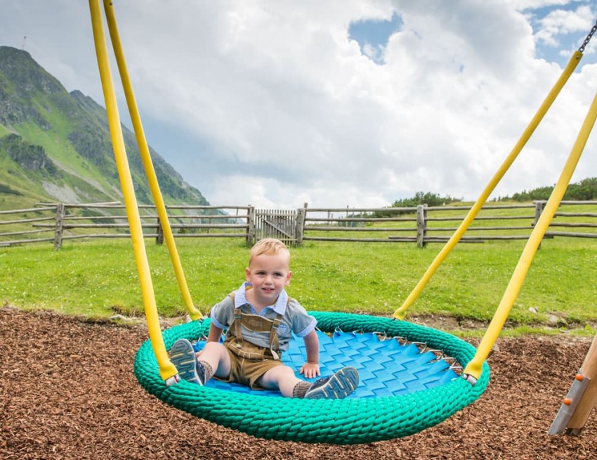Kind schaukelt auf dem Spielplatz